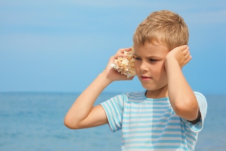 kid listening to a seashell
